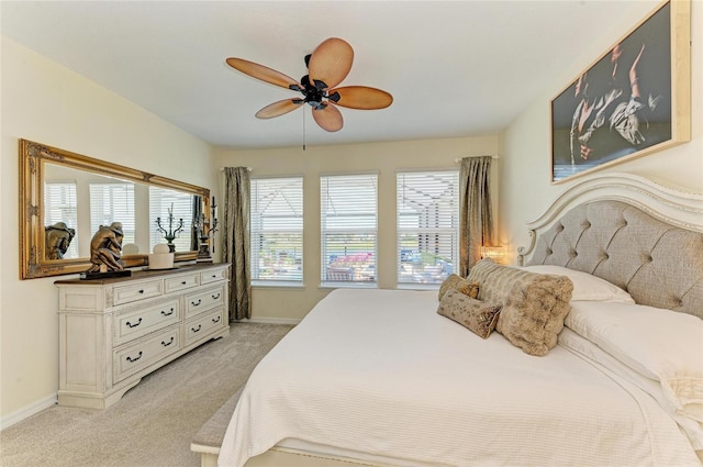 bedroom featuring baseboards, light carpet, and a ceiling fan