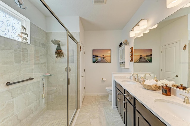 bathroom featuring a sink, toilet, and a shower stall