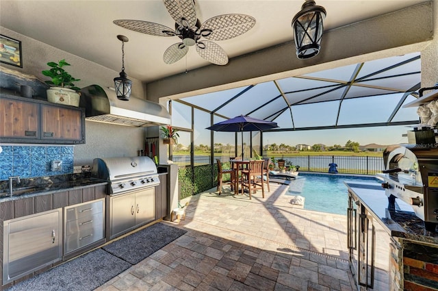 view of patio / terrace with a lanai, area for grilling, exterior kitchen, and fence