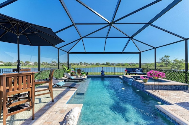 outdoor pool with glass enclosure, a patio, and a water view