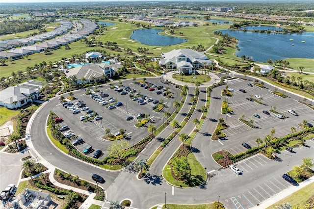 drone / aerial view with a water view and golf course view