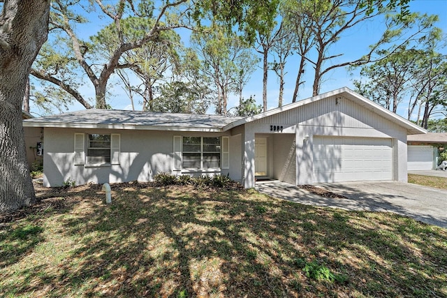 ranch-style home with stucco siding, driveway, a front yard, and an attached garage