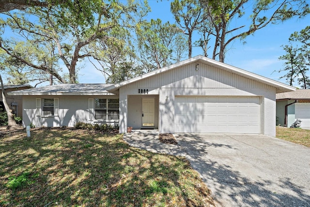 ranch-style home featuring concrete driveway, a front lawn, a garage, and stucco siding