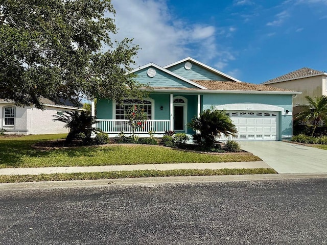 view of front of house featuring covered porch, an attached garage, driveway, and a front yard