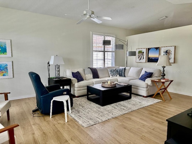 living area featuring visible vents, baseboards, light wood-style flooring, and a ceiling fan