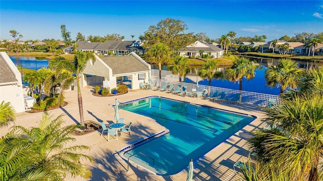 community pool with a residential view, a water view, a patio, and fence