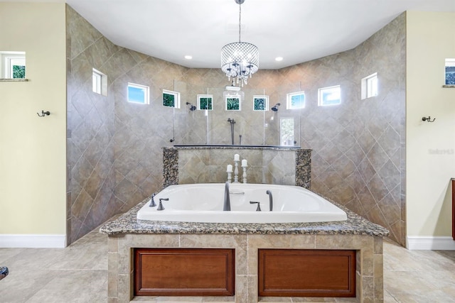 full bath featuring a garden tub, baseboards, a chandelier, and walk in shower