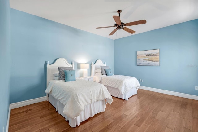 bedroom featuring a ceiling fan, wood finished floors, and baseboards