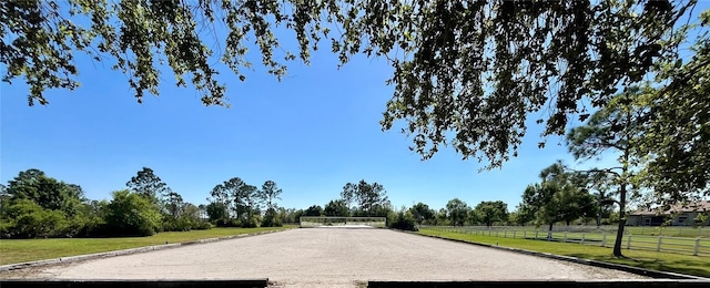 view of community with a yard and fence