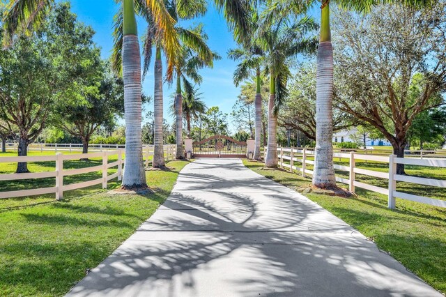 3551 Ridgeland Ct, Punta Gorda, FL 33982 - view of home's community with a lawn, concrete driveway, fence, and a gate