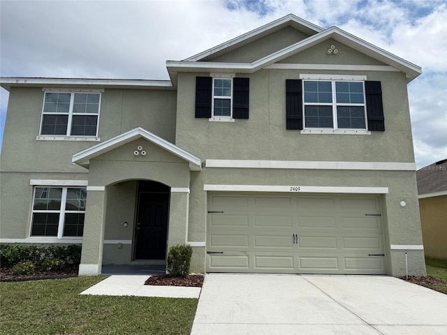 view of front of house featuring stucco siding, driveway, and a garage