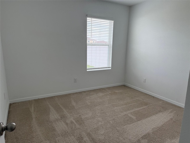 empty room with light carpet and baseboards