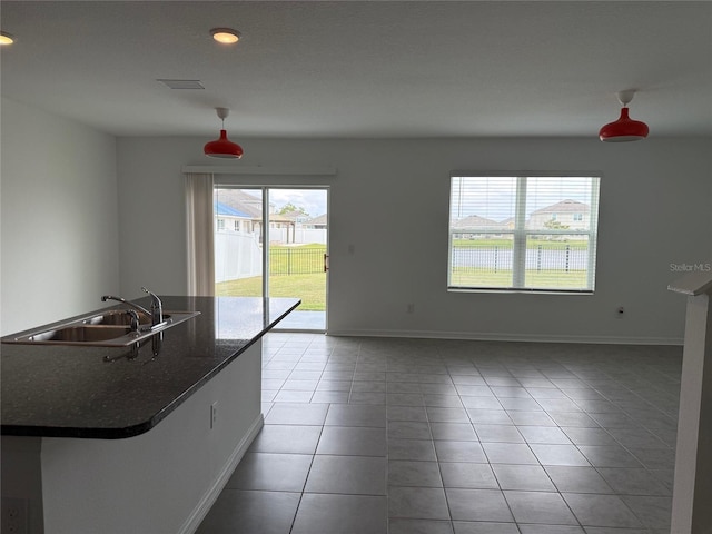 interior space featuring tile patterned flooring, baseboards, and a sink