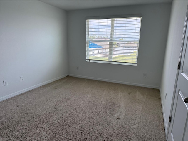 carpeted empty room with baseboards