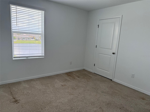 carpeted empty room with baseboards