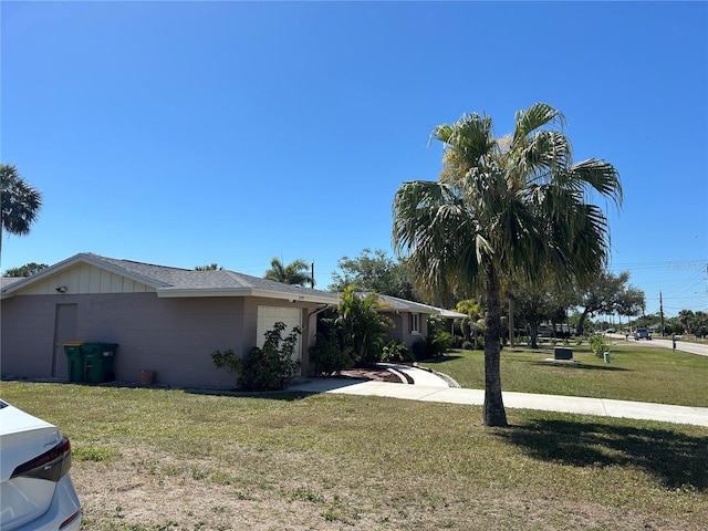 view of property exterior with concrete block siding, a yard, driveway, and an attached garage