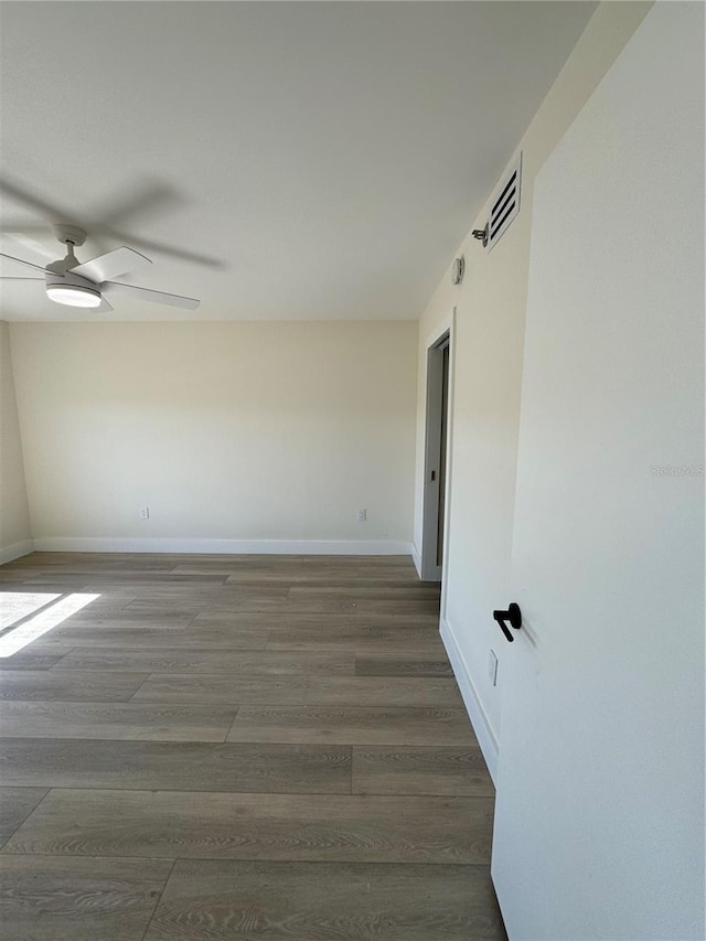 empty room featuring visible vents, baseboards, ceiling fan, and wood finished floors