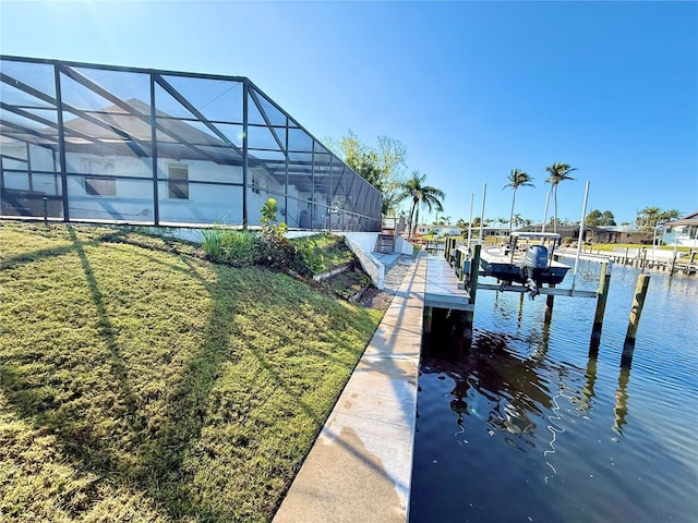 view of dock with a lanai, a yard, a water view, and boat lift