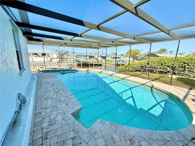 pool featuring a lanai, a patio, and a water view