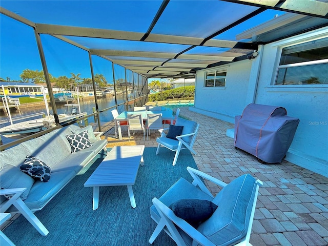 view of patio featuring a water view, a boat dock, an outdoor living space, glass enclosure, and a grill