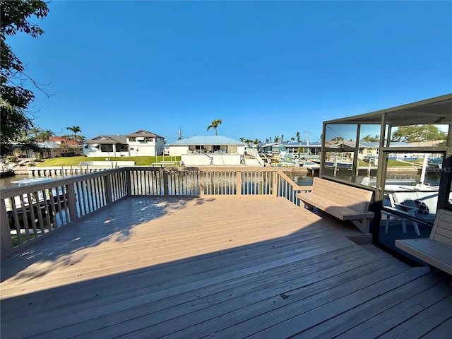 wooden deck with a residential view and a water view