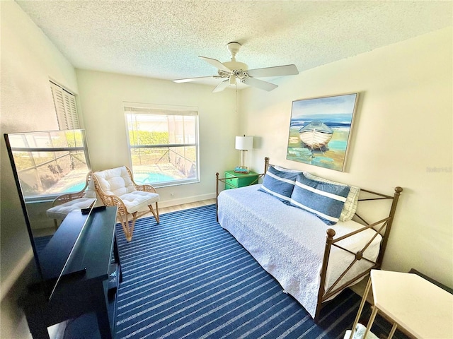 bedroom featuring baseboards, a textured ceiling, and ceiling fan