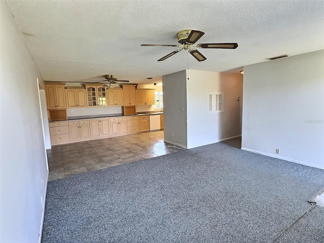 unfurnished living room with visible vents, dark tile patterned floors, a textured ceiling, dark carpet, and ceiling fan