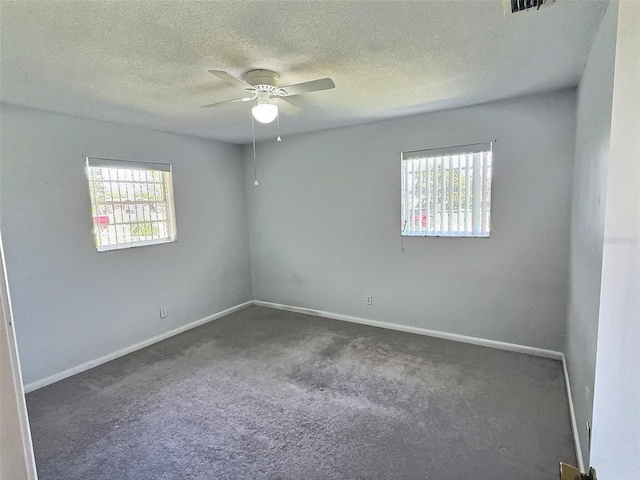 empty room with a ceiling fan, baseboards, carpet floors, and a textured ceiling