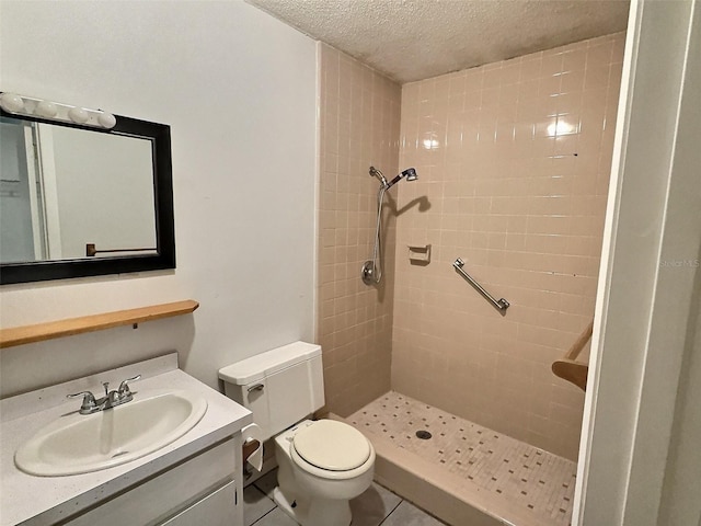 bathroom with vanity, tile patterned flooring, a shower stall, a textured ceiling, and toilet