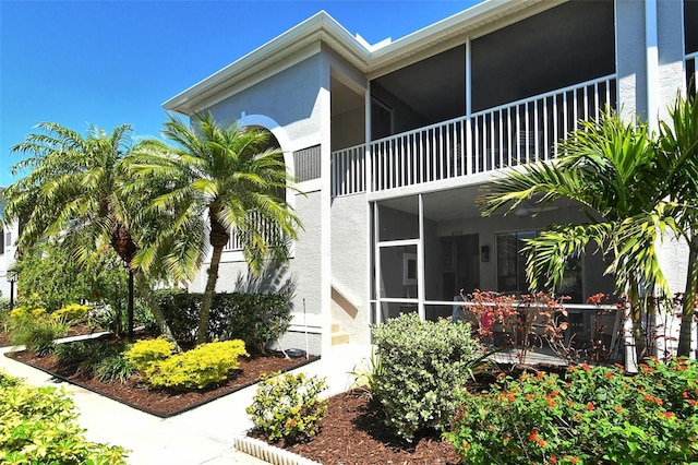 view of property exterior featuring a sunroom and stucco siding