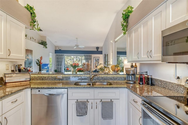 kitchen featuring a healthy amount of sunlight, white cabinets, stainless steel appliances, and a sink