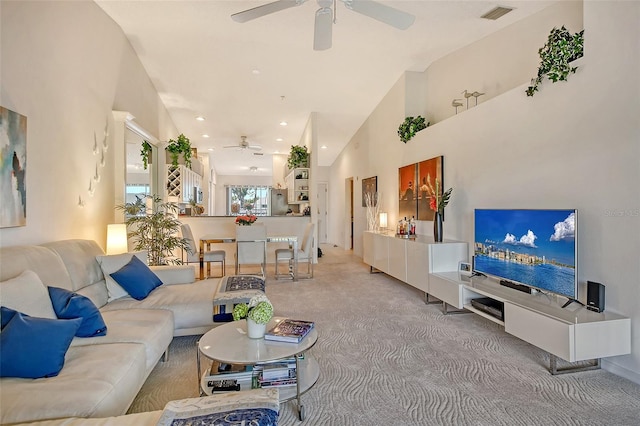 living area featuring a ceiling fan, visible vents, high vaulted ceiling, recessed lighting, and light colored carpet