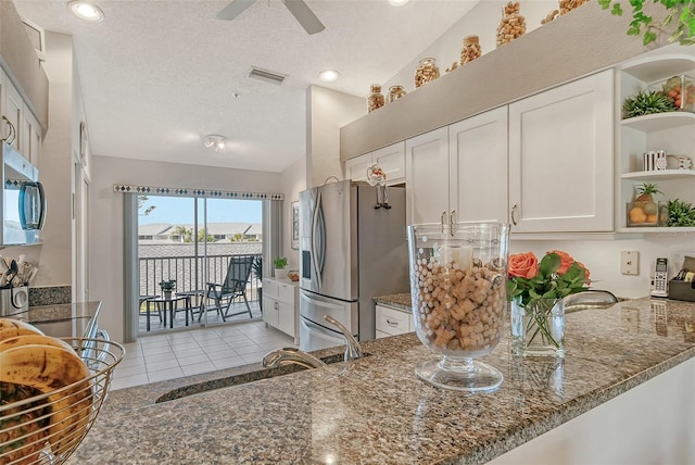 kitchen with visible vents, dark stone countertops, appliances with stainless steel finishes, and open shelves