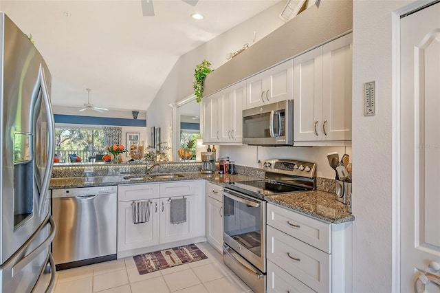 kitchen with a ceiling fan, a sink, white cabinetry, appliances with stainless steel finishes, and light tile patterned flooring