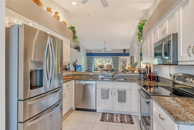 kitchen featuring a ceiling fan, light tile patterned flooring, a sink, stainless steel appliances, and white cabinetry