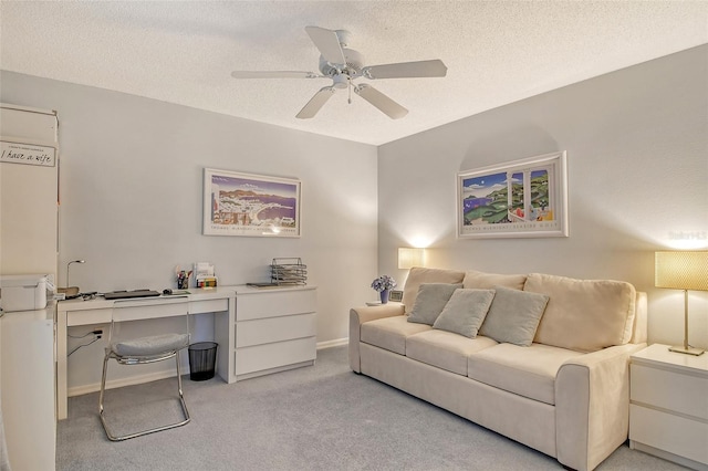 interior space with a textured ceiling, light colored carpet, baseboards, and ceiling fan