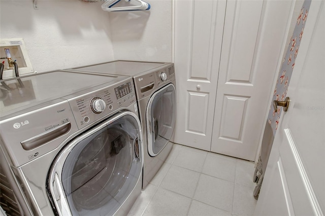 laundry room featuring washer and dryer, laundry area, and light tile patterned floors