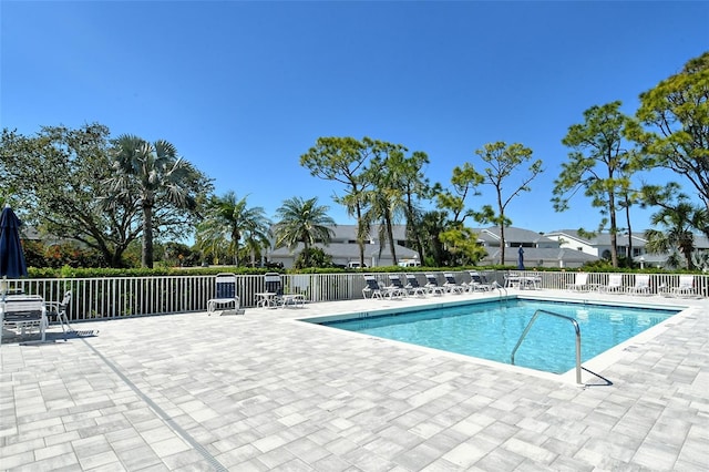 pool with a patio area and fence