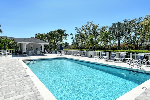 community pool with a patio and fence