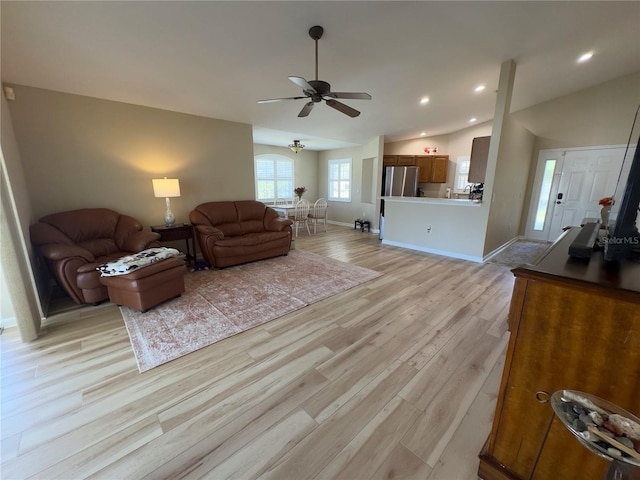 living area with a ceiling fan, recessed lighting, light wood finished floors, baseboards, and vaulted ceiling