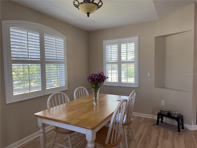 dining space featuring baseboards and light wood-style floors