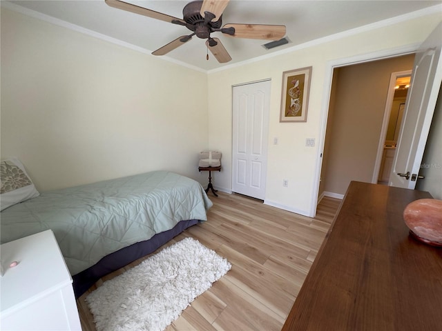 bedroom featuring crown molding, light wood-style flooring, and baseboards