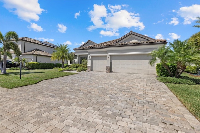 view of front of property with a tiled roof, a front yard, stucco siding, decorative driveway, and an attached garage