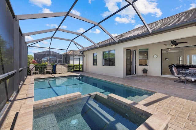 view of swimming pool featuring a lanai, a pool with connected hot tub, ceiling fan, and a patio area