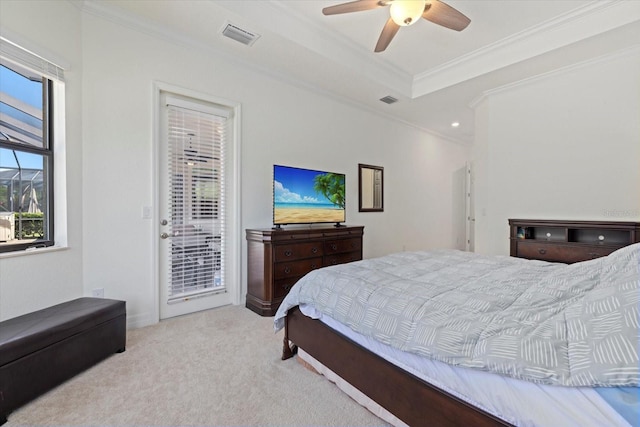 carpeted bedroom featuring access to exterior, visible vents, a tray ceiling, and ornamental molding