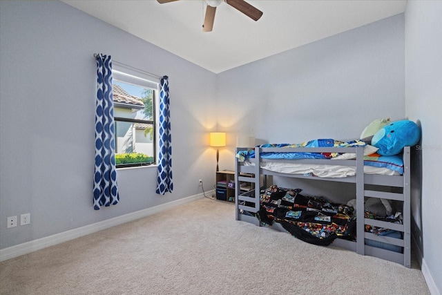 carpeted bedroom featuring baseboards and ceiling fan