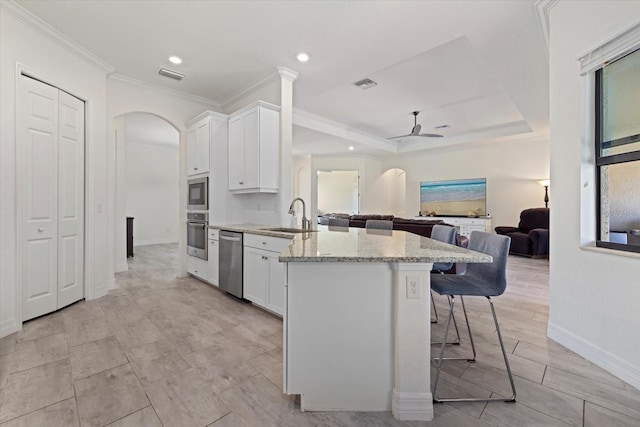 kitchen featuring visible vents, a ceiling fan, a sink, arched walkways, and appliances with stainless steel finishes