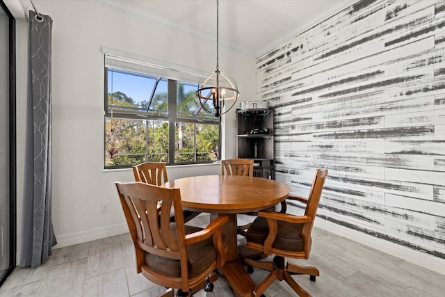 dining area with baseboards, wood walls, an accent wall, crown molding, and a chandelier