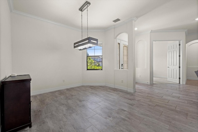 unfurnished dining area featuring arched walkways, visible vents, baseboards, and ornamental molding