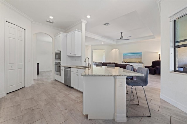 kitchen with visible vents, a ceiling fan, a sink, arched walkways, and appliances with stainless steel finishes